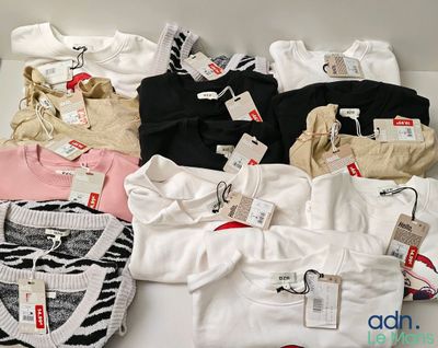 un grand nombre de t-shirts posés sur une table
