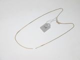 a necklace with a tag on it sitting on top of a white surface