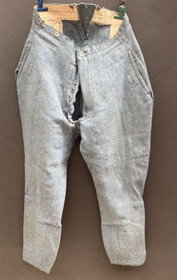 an old pair of jeans hanging on a hanger on a wall