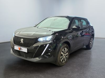 La voiture noire est garée dans une grande pièce au sol noir.