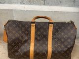 louis vuittou bag on the ground next to a wall