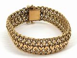 a close up of a gold bracelet on a white background