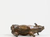 a bronze sculpture of a pig on a white background