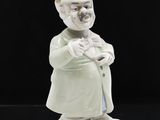 une figurine représentant un homme avec un chapeau et une canne