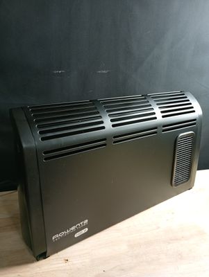a black air conditioner sitting on a wooden table