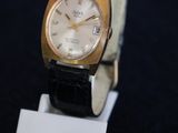an image of a gold and black watch on a stand