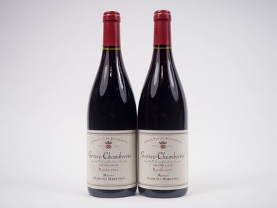 deux bouteilles de vin rouge posées l'une à côté de l'autre sur une surface blanche
