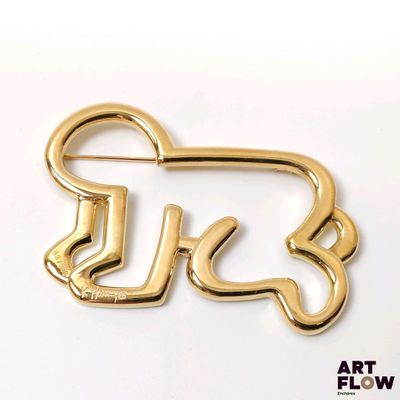 a gold pin with the word u k on it