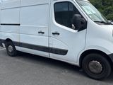 the white van is parked in a parking lot with trees in the background