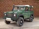 a green land rover parked in front of a brick wall