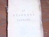un vieux livre posé sur une table en bois sur laquelle est inscrit un numéro