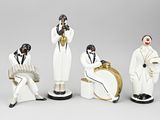 three figurines of men dressed in black and white sitting next to each other