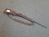 an old rifle is laying on the floor next to a piece of luggage