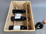 three bottles of wine in a wooden box on a table