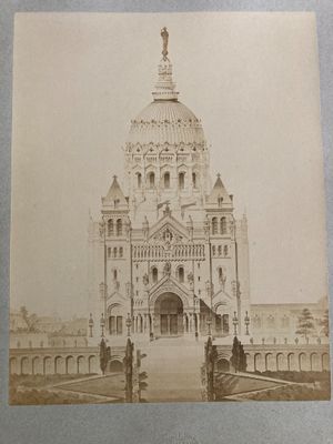 an old photo of a large building with a clock on it