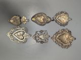 five silver brooches and two other silver brooches on a table