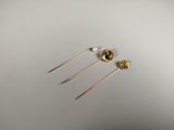 deux paires de boucles d'oreilles en or ornées de perles, posées sur une surface blanche