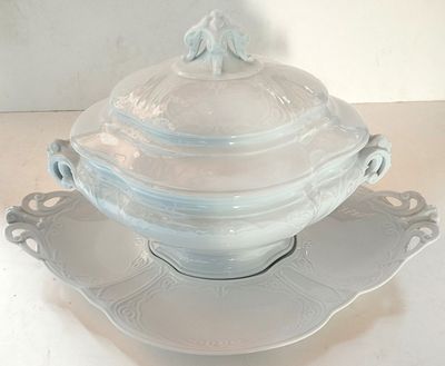 a white bowl with a lid on a saucer on a plate