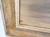 une image montrant un gros plan d'un tableau accroché à un mur blanc