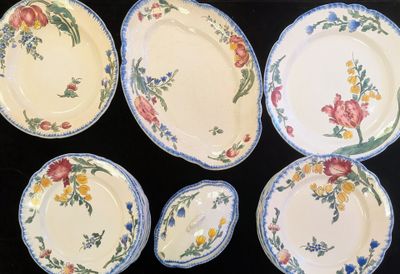 six assiettes aux motifs variés, disposées sur une table noire