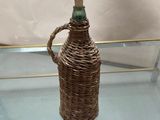 a glass table with a wicker bottle on it