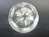 a clear glass object on a table with a black background