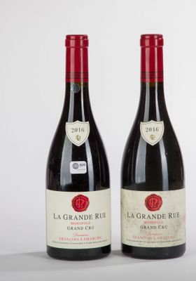 two bottles of red wine sitting next to each other on a table