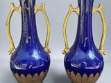 pair of blue and gold vases with handles on each of them