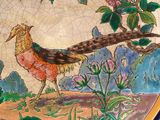 a plate with a bird painted on it on a table