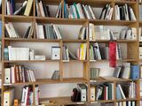 a book shelf with many books on it in a room