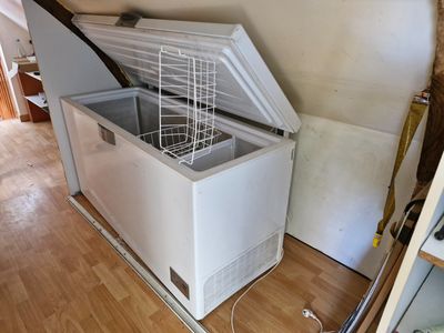 a white chest freezer sitting in the corner of a room