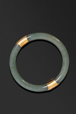 un gros plan d'un bracelet vert posé sur une surface noire