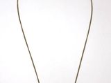 un collier en or muni d'une chaîne sur laquelle est accrochée une croix