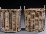 pair of wicker baskets with handles on a grey background