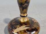 un vase marron et noir sur lequel est représenté un insecte