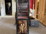 a tall cabinet with a painting on it in the middle of a room