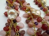 a close up of a necklace with pearls and gems