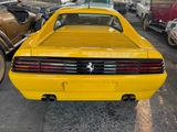 a yellow car parked in a parking lot with other cars