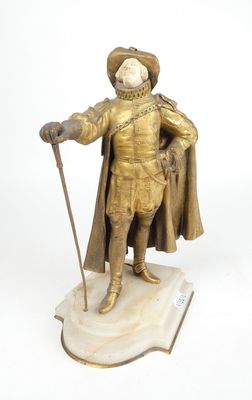 figurine représentant un homme vêtu d'une tenue dorée et tenant une canne