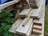 un tas de bois posé sur le sol à côté d'un bâtiment