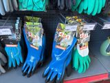 several pairs of gardening gloves are on display in a store