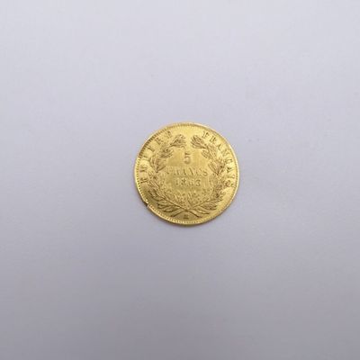 a close up of a gold coin on a white surface