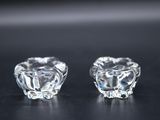 pair of clear glass candlestick holders on a black surface