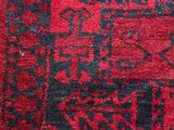 an old rug with a red and black design on it