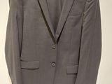 a suit hanging on a hanger on a wall