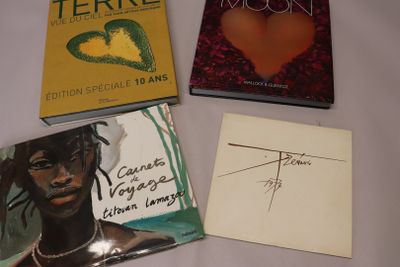 Trois livres sont posés sur une table, avec un mot devant eux.