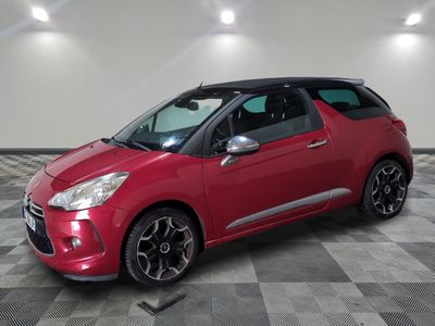 a red citrole parked on a checkered floor in a garage