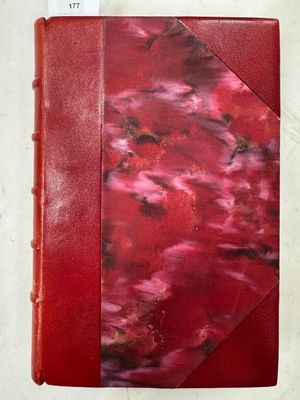 un gros plan d'un livre rouge posé sur une surface blanche