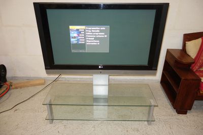 a flat screen tv sitting on a glass table in a living room