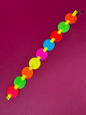 a close up of a colorful bracelet on a purple surface